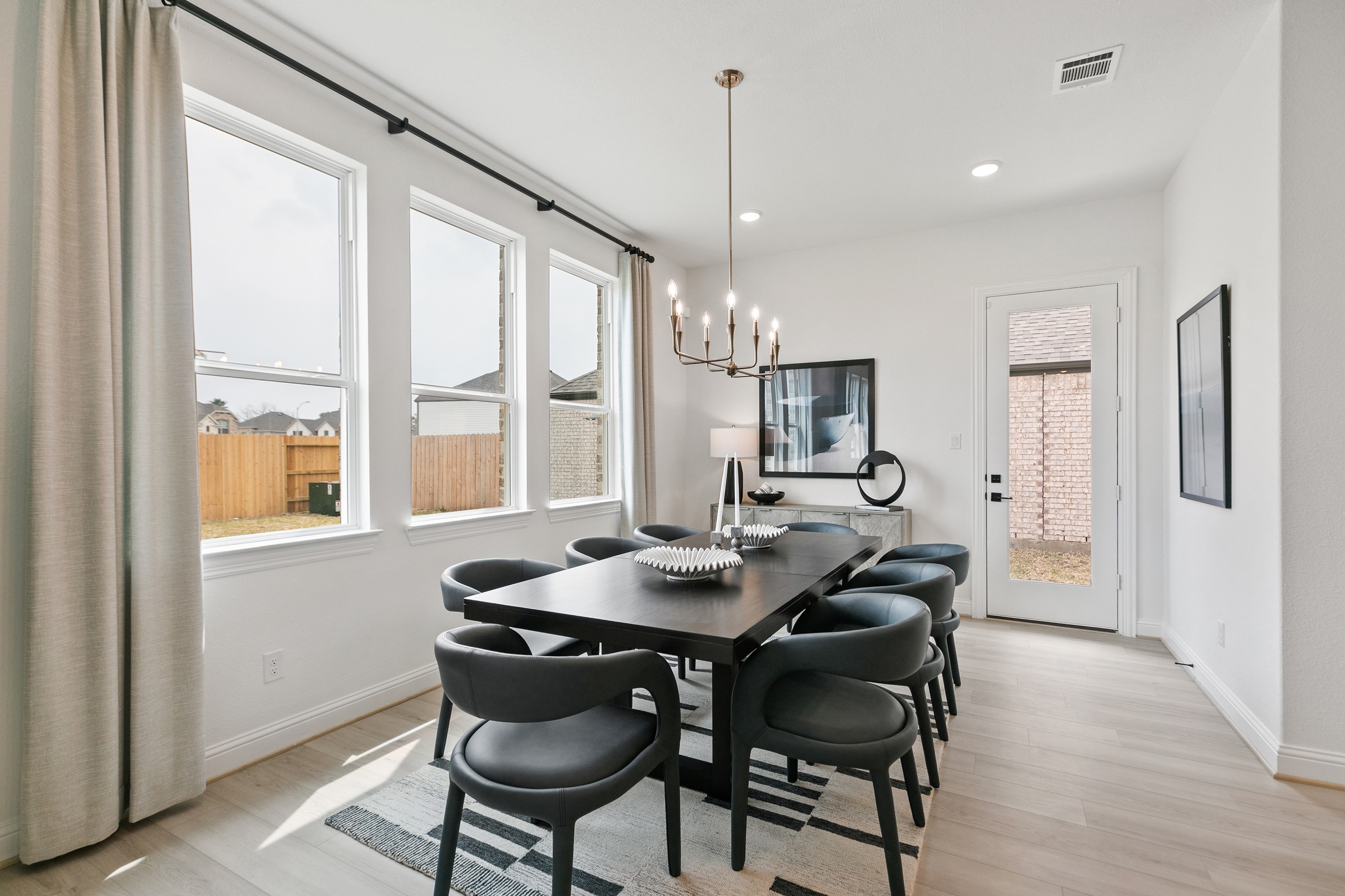 Modern Dining Room in Park at Eldridge, Houston Elegant dining room with modern chandelier, large windows, and sleek furniture in Park at Eldridge, Houston.