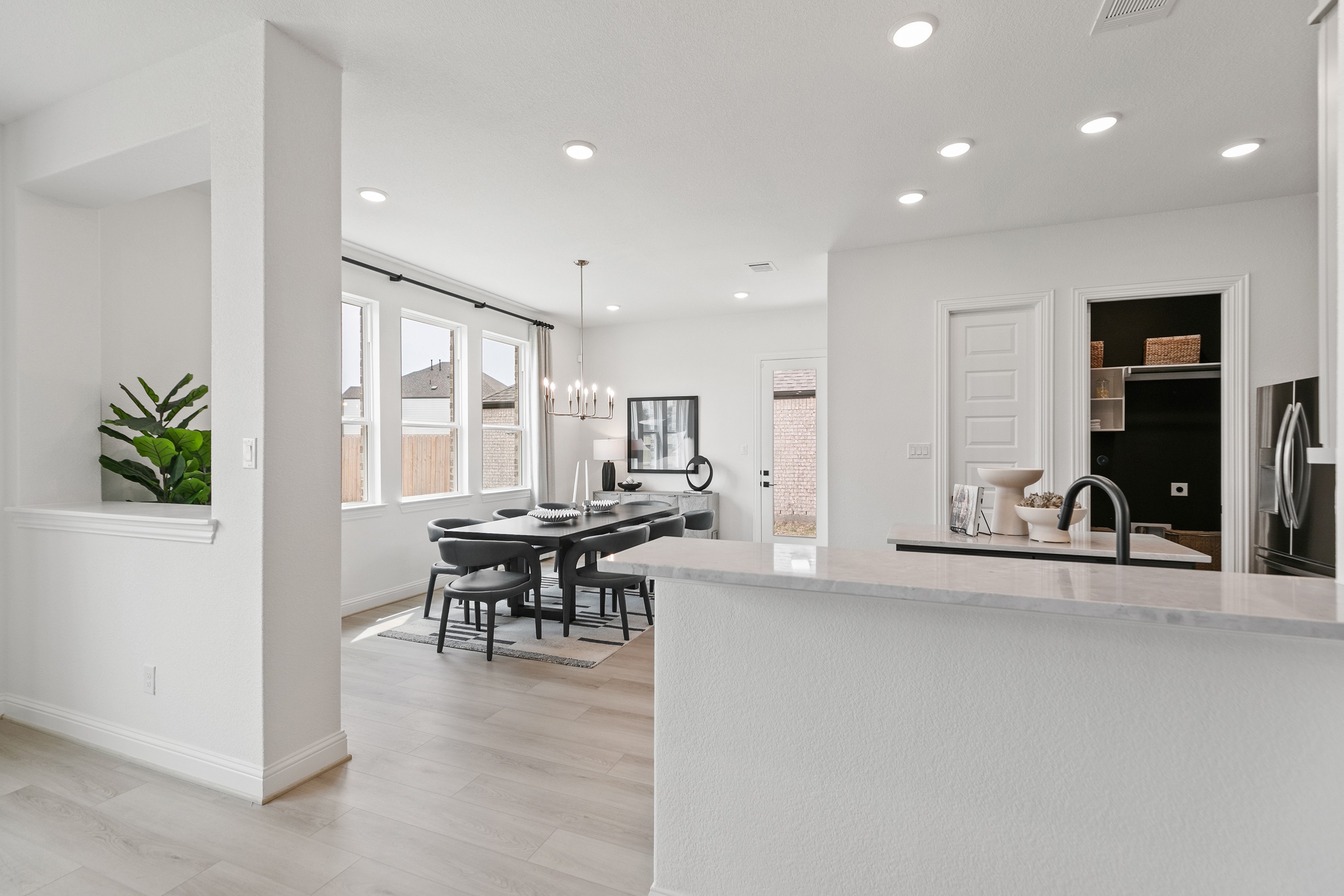 Modern Dining Area Park at Eldridge Houston Modern dining area with sleek chandelier, hardwood floor, and large windows in Park at Eldridge, Houston.