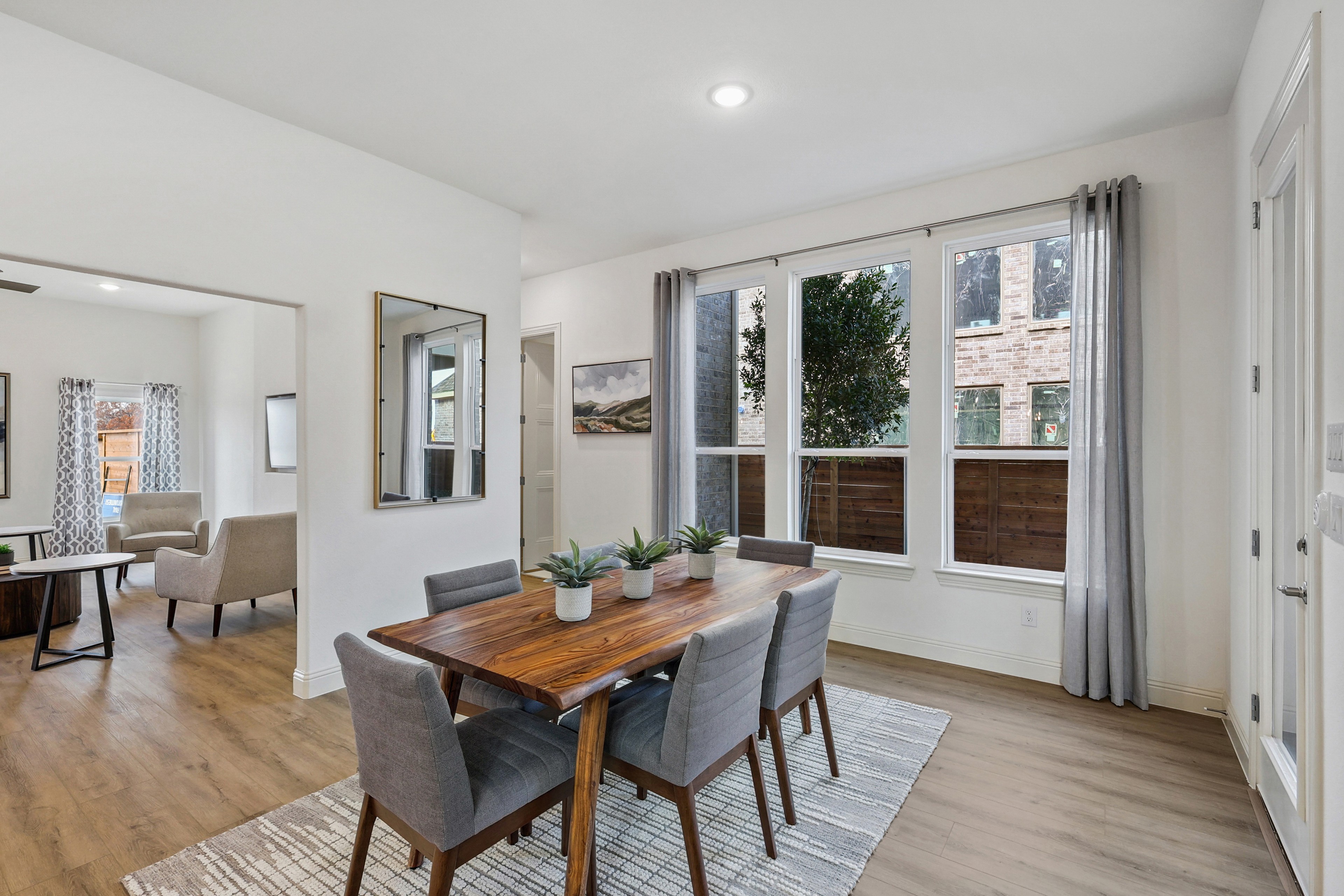 Dining Room with Modern Decor and Large Windows in Solterra, Texas Elegant dining room with large windows, hardwood floors, and contemporary decor in Solterra, Texas.