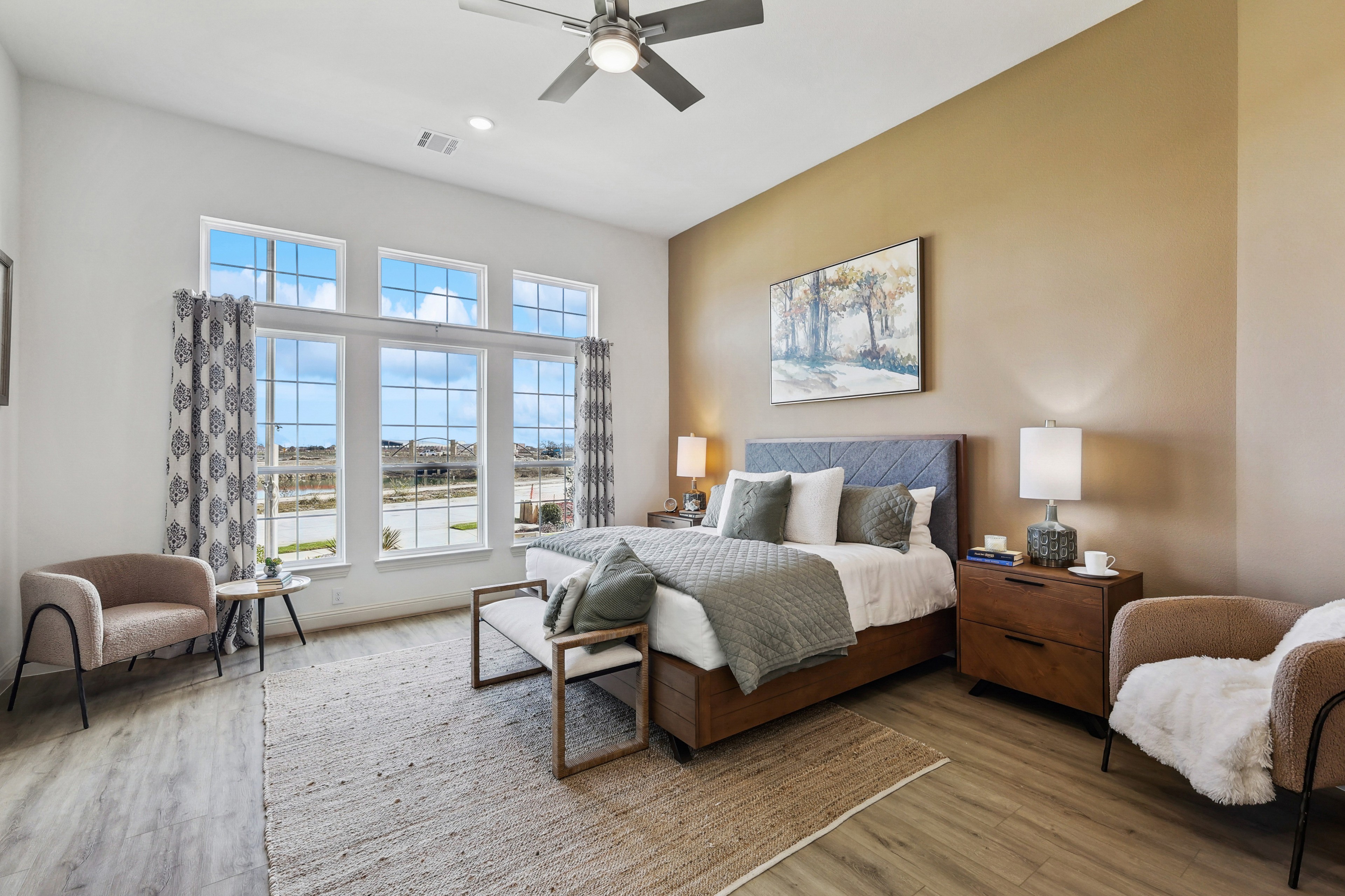 Elegant Bedroom Design in Solterra Texas Community Home Spacious bedroom with large windows, hardwood floors, luxury decor in Solterra, Texas.