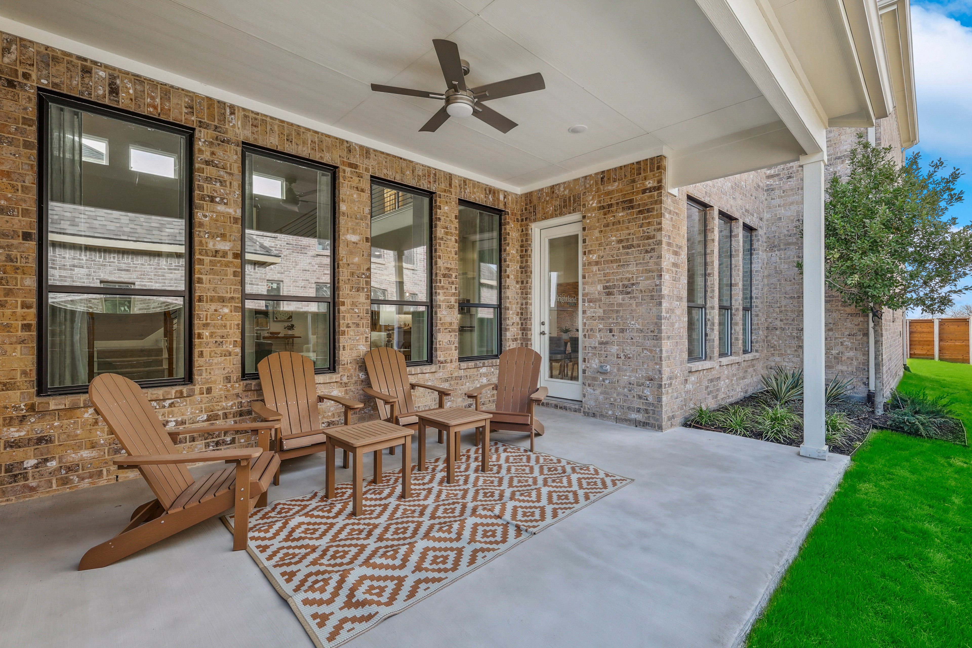Elegant Covered Patio with Brick Walls in Solterra, Texas Covered patio with Adirondack chairs, brick walls, ceiling fan in Solterra, Texas. Modern outdoor space.