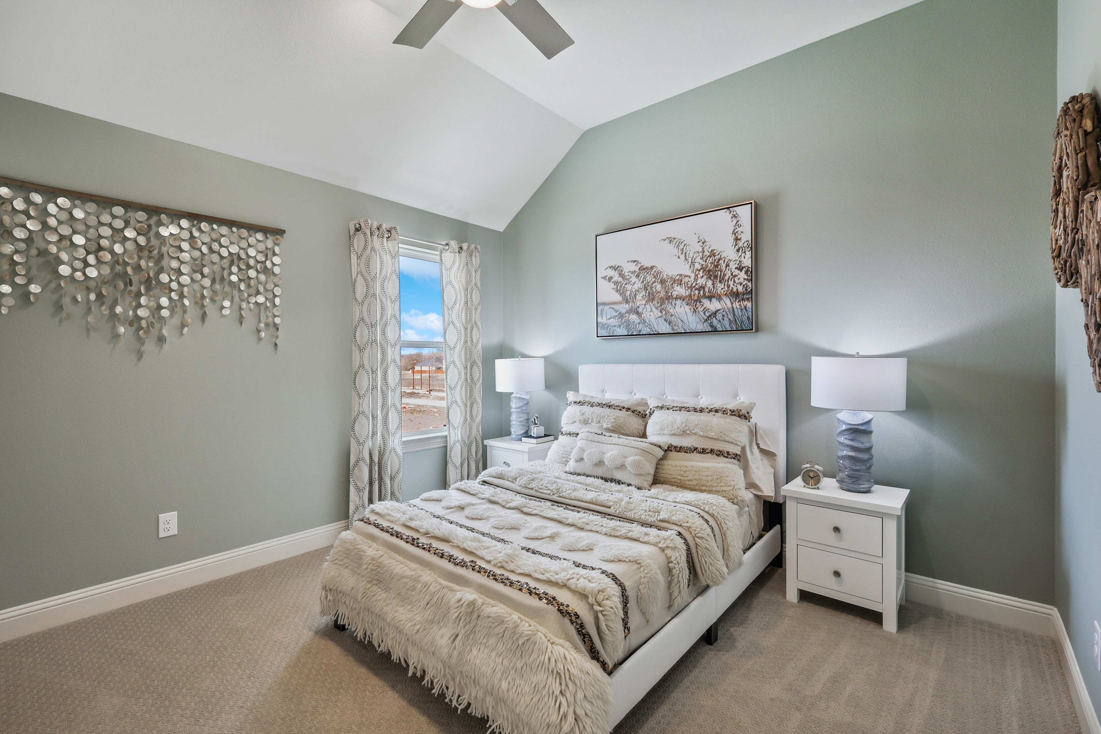 Solterra Texas Bedroom with Vaulted Ceiling and Modern Decor Stylish bedroom in Solterra Texas with vaulted ceiling, modern decor, and soft tones. Large window offers natural light.