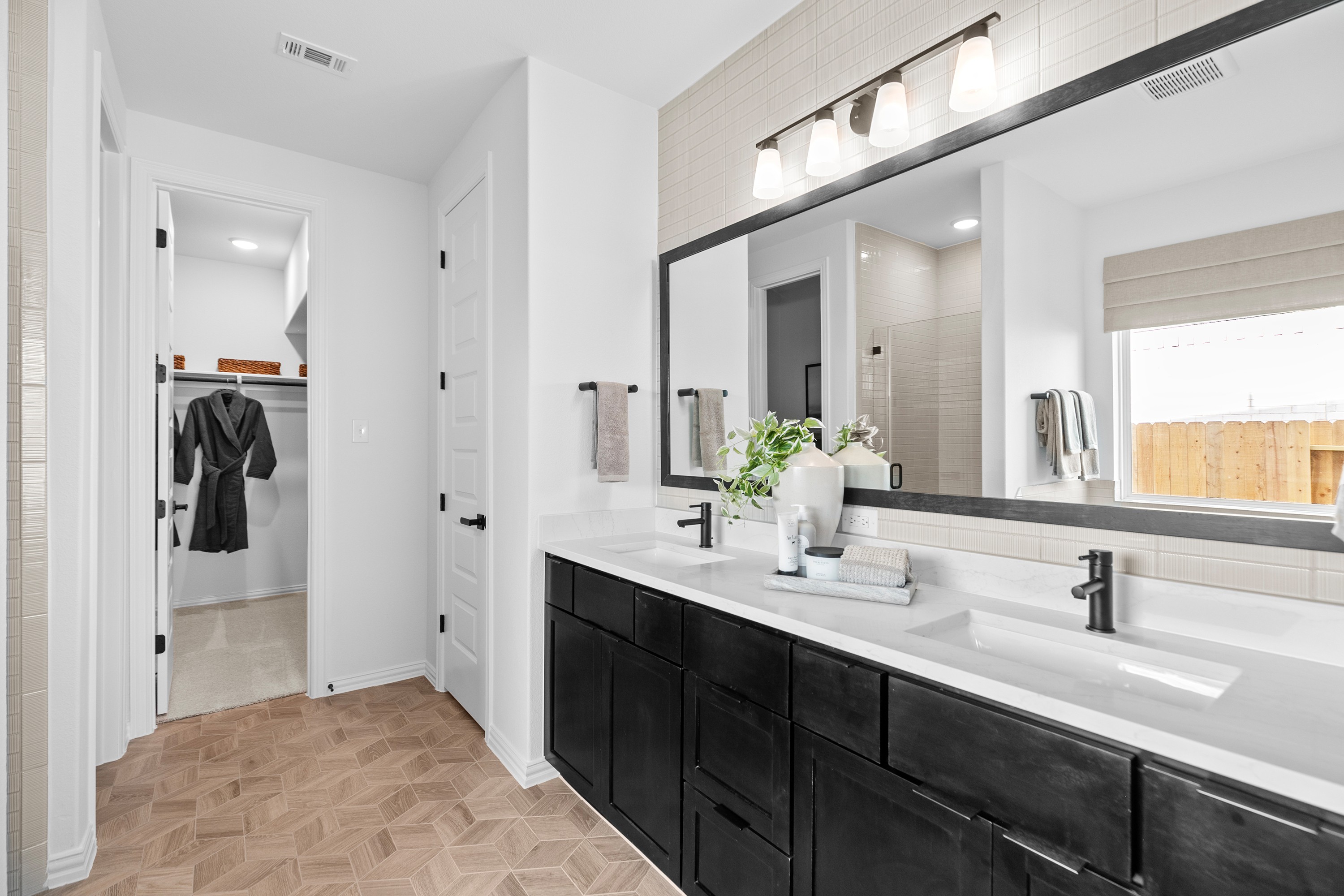 Luxurious Black Cabinet Bathroom in River Ranch Community Modern bathroom with black cabinets, geometric flooring, in River Ranch community. Features large mirror and elegant lighting.