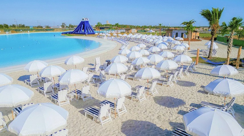 Luxury Beachfront Resort with Pool in River Ranch Community Luxury beach resort with white umbrellas, loungers, and large pool in River Ranch. Palm trees enhance tropical feel.