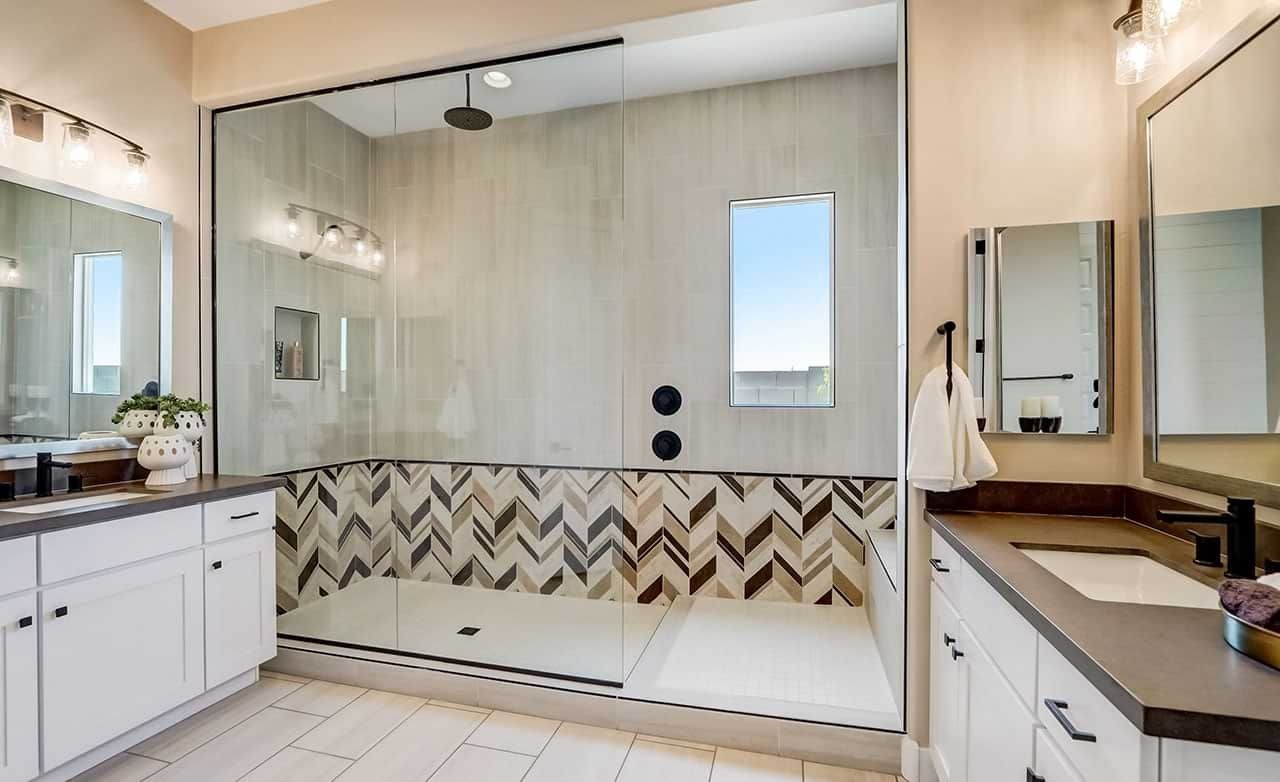 Elegant Hacienda Bathroom with Chevron Tiles in Canyon Views Luxurious bathroom in Hacienda home with large glass shower, chevron tiles, and double vanity, Canyon Views.