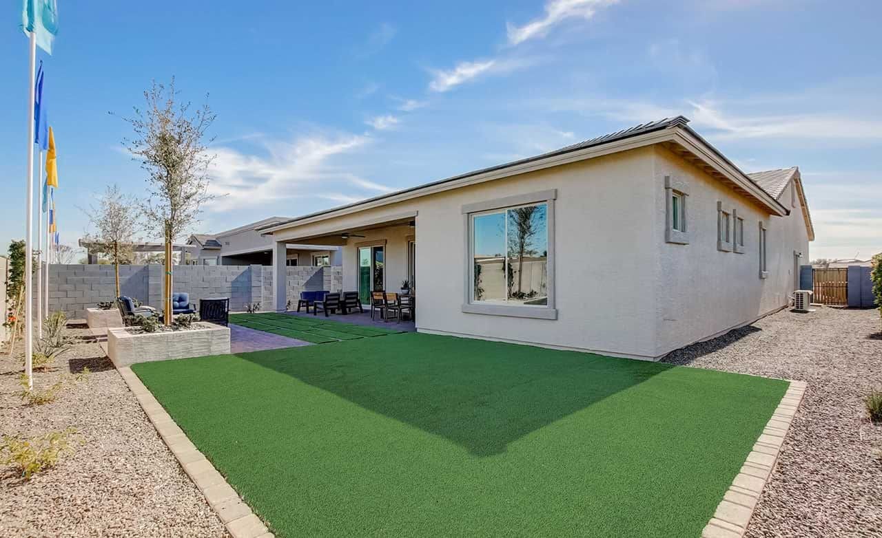 Modern Home with Yard in Mirada Crossing, Arizona Modern house with synthetic lawn, patio, and brick fence in Mirada Crossing community, Arizona.