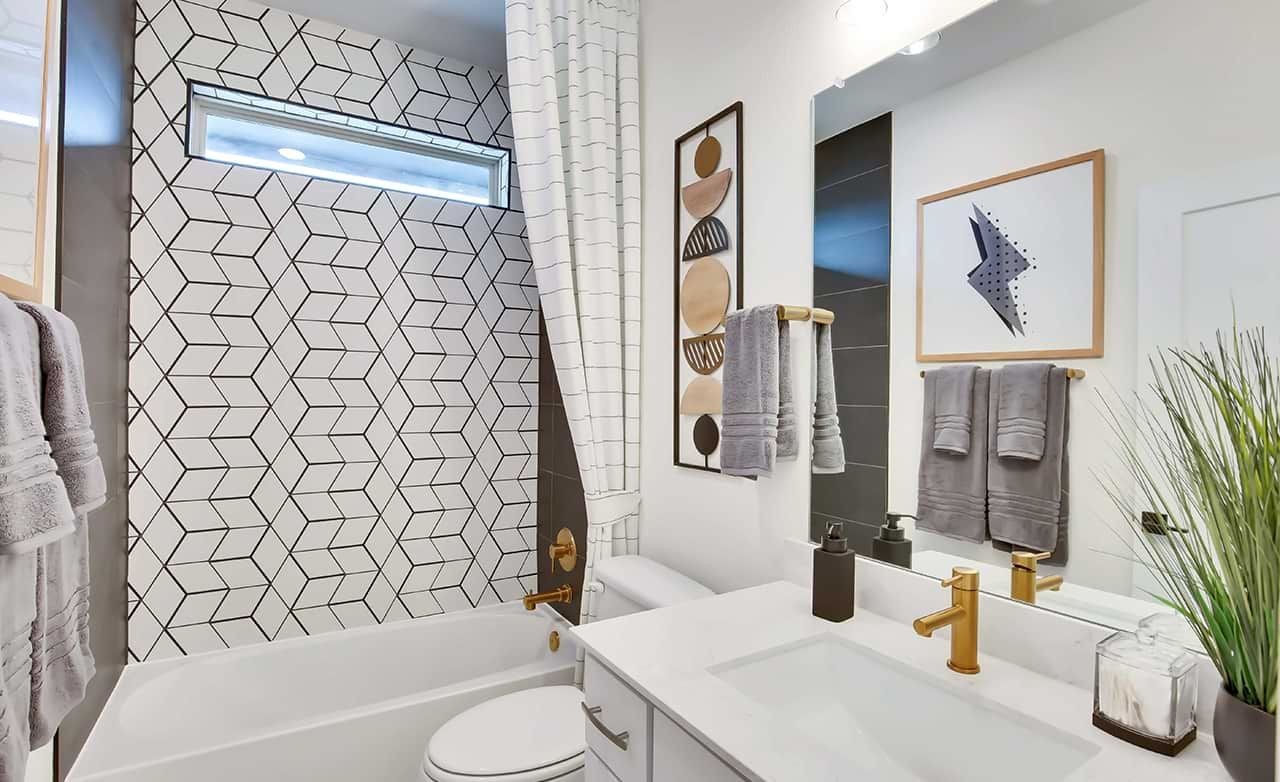 Oaks at San Gabriel Modern Bathroom with Geometric Tile Design Modern bathroom with gold fixtures, geometric tiles, and minimalist decor in Oaks at San Gabriel, Texas.