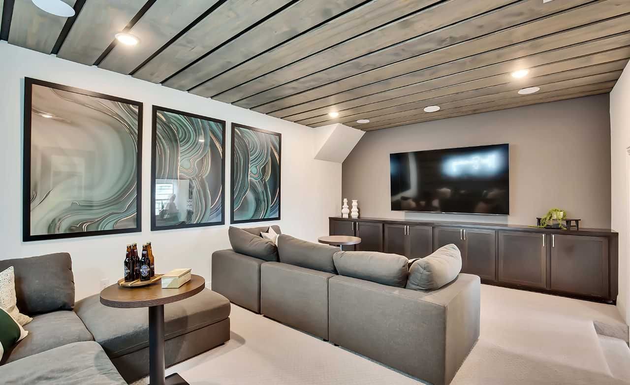 Luxury Media Room at Oaks at San Gabriel, Texas Luxury media room with modern wood ceiling, abstract art, plush sofa. Oaks at San Gabriel, Texas.
